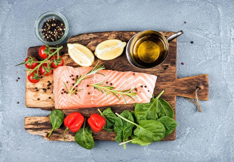 tabla de madera con un corte de salmon y verduras