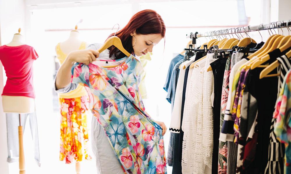 mujer midiendose un vestido largo en un negocio