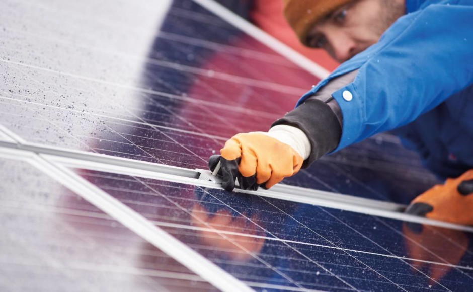 Hombre realizando limpieza y mantenimiento preventivo a un panel solar