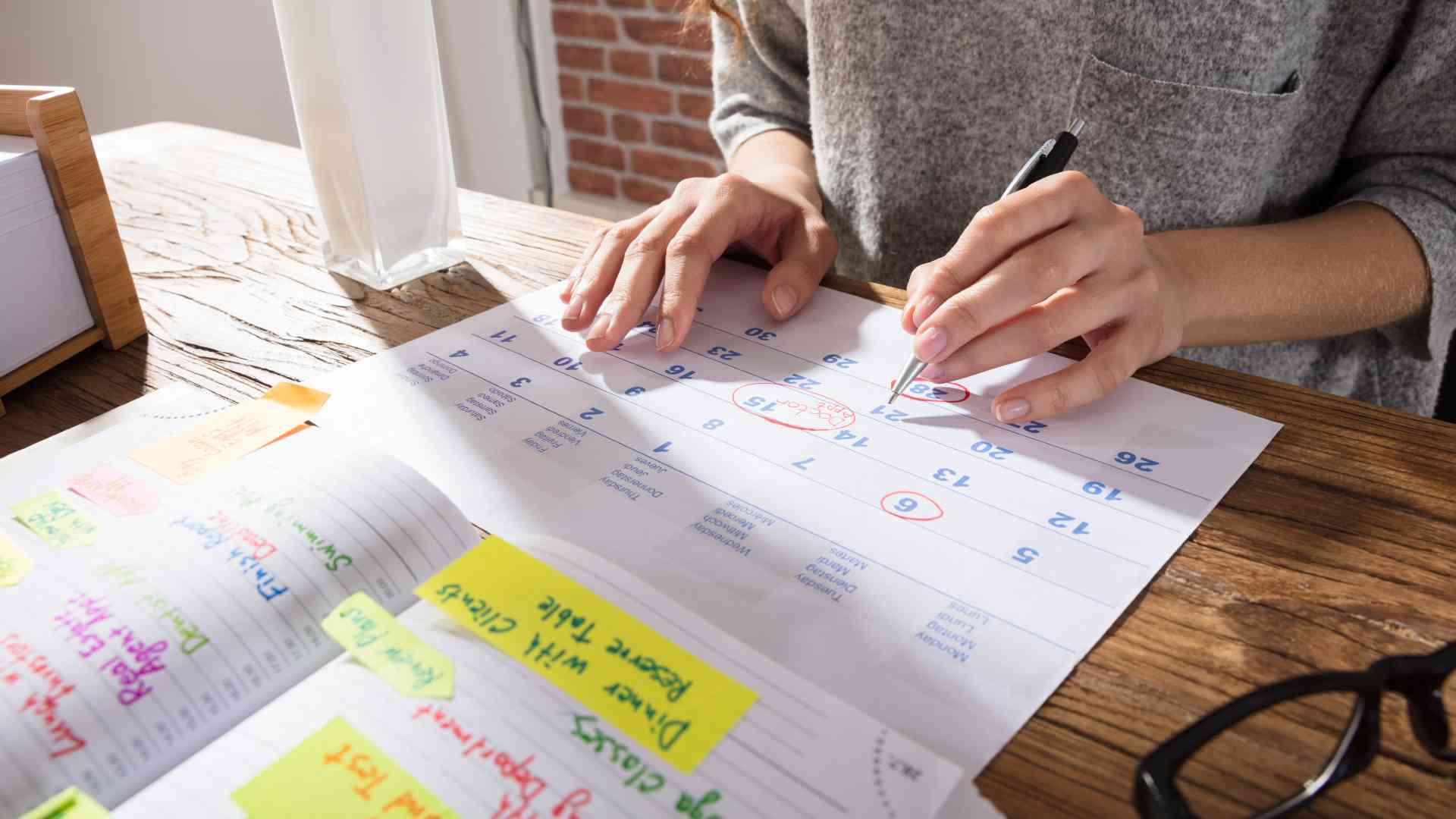 Mujer decidiendo fechas frente a un calendario para organizar un evento