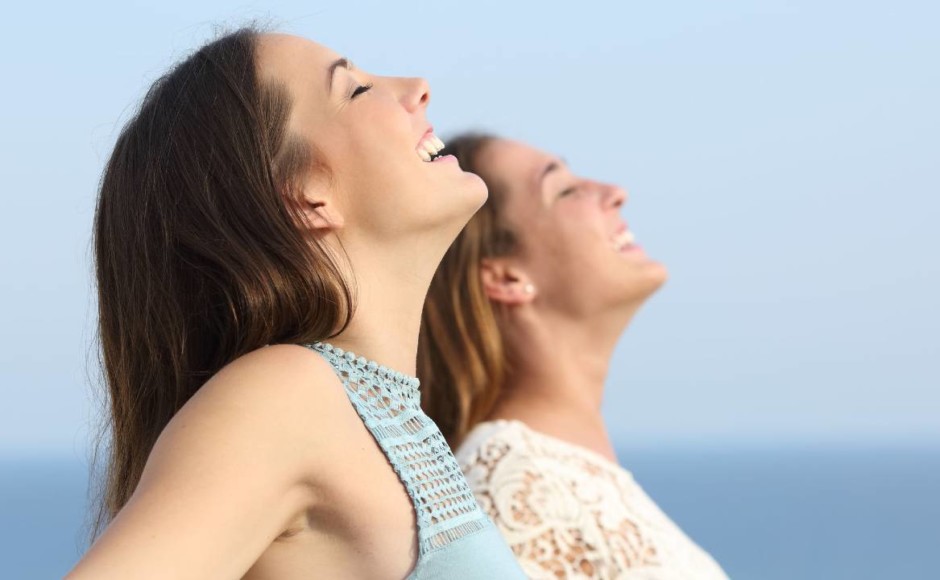 Mujeres sonriendo frente al mar azúl