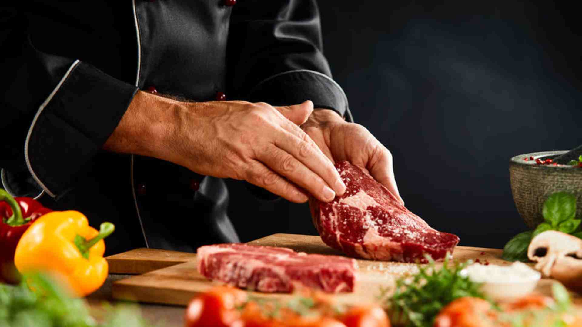 Manos de un Chef preparando la carne para asarla a la parrilla