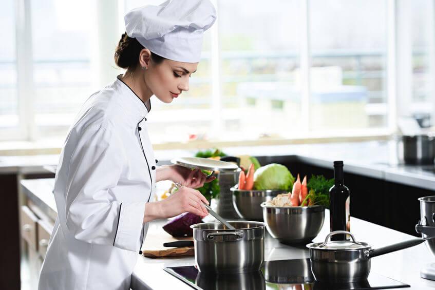 mujer chef degustando un platillo preparado por ella