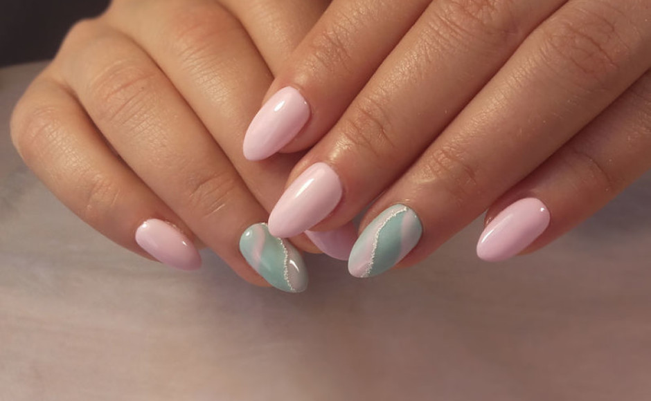 manos de mujer con un manicure acrílico en una mesa