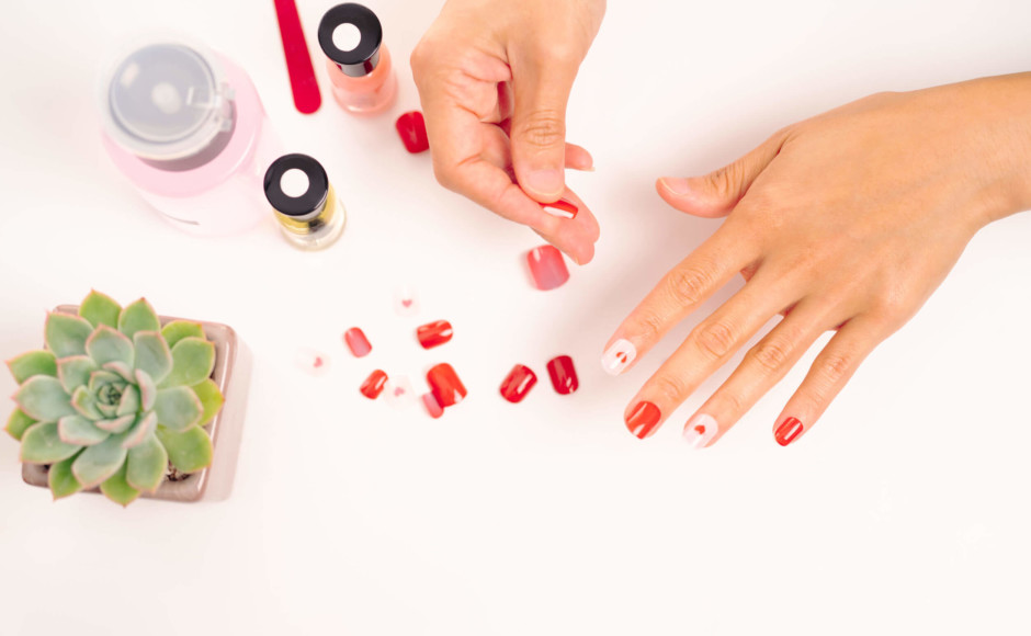 Mãos de mulher selecionando diferentes tipos de unhas de acrílico