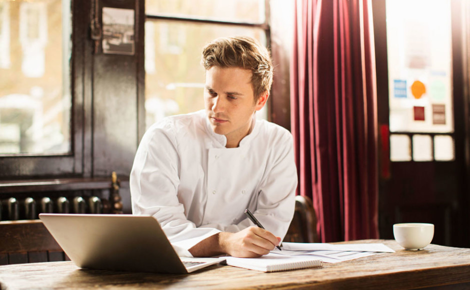 hombre en un negocio con su computadora tomando notas