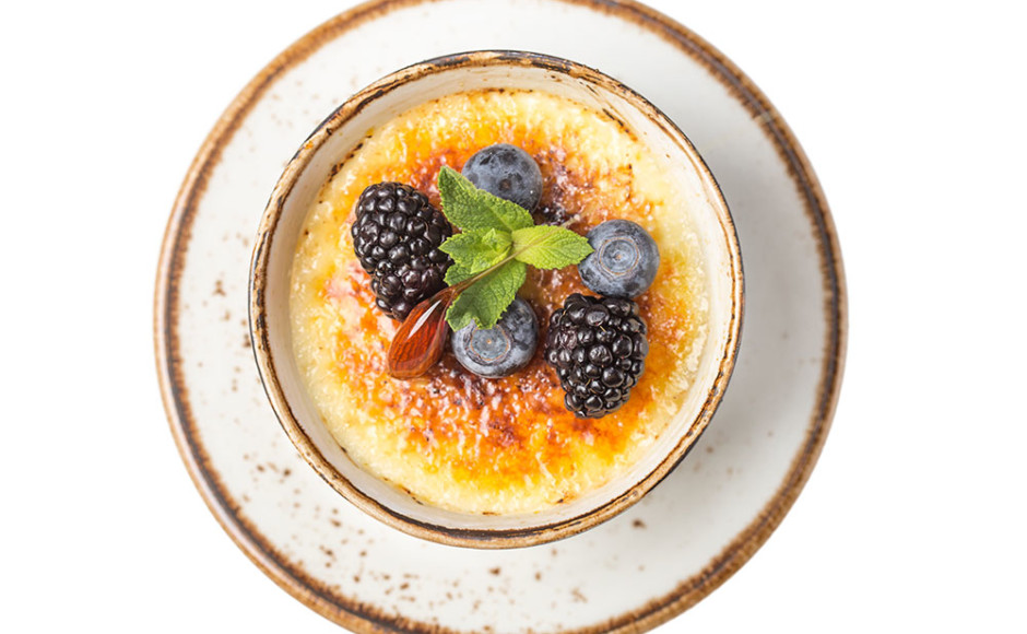 crème brûlée con moras sobre un plato
