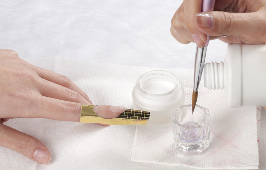 manicurista poniendo uñas acrílicas en el salon de belleza