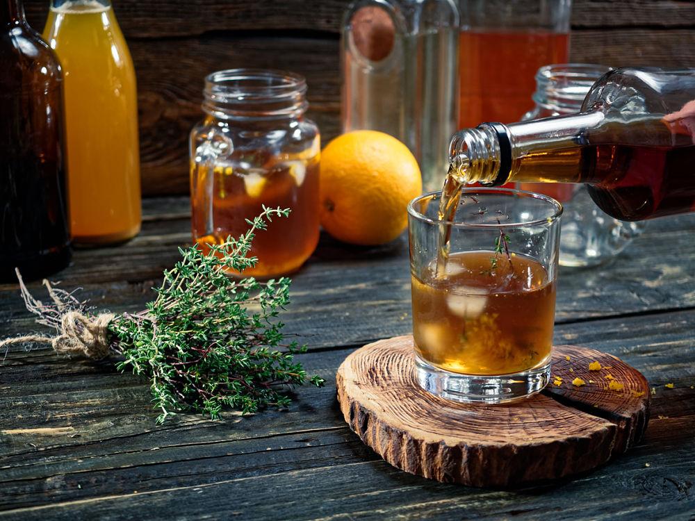 dos vasos de bebida de manzana y naranja con una botella de whiskey