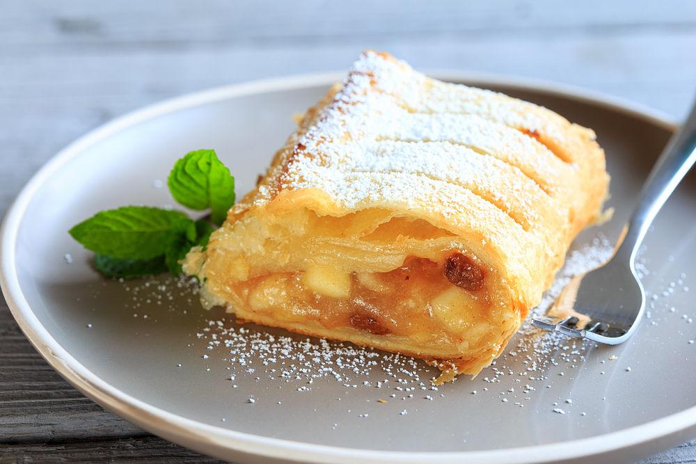 strudel de manzana sobre un plato gris decorado con una hoja de hierbabuena