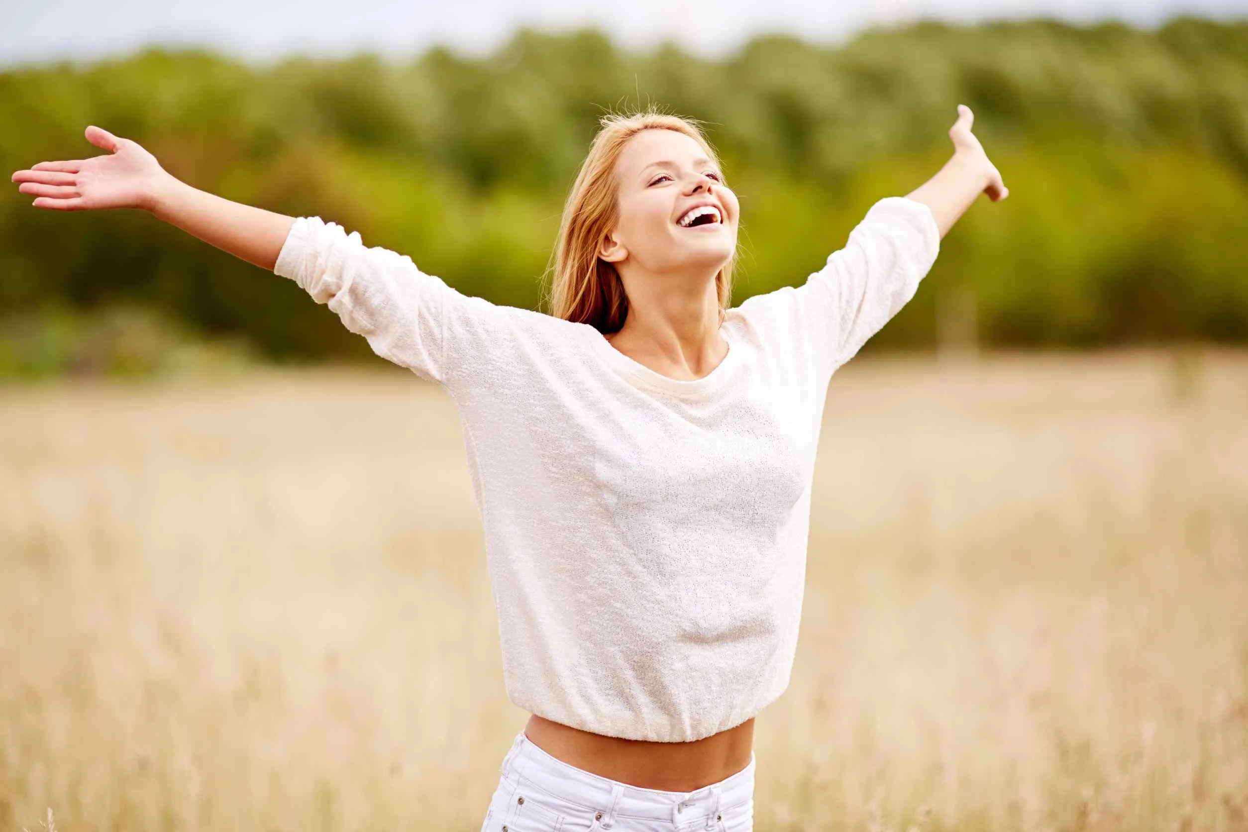 mujer feliz corriendo sobre un campo