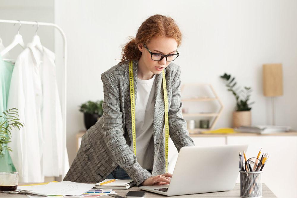 mujer con un metro revisando un computador