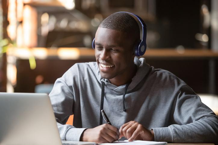 hombre sonriendo mientras observa un computador