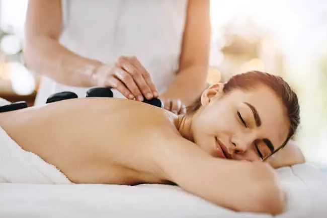 mujer recibiendo masajes con piedras calientes