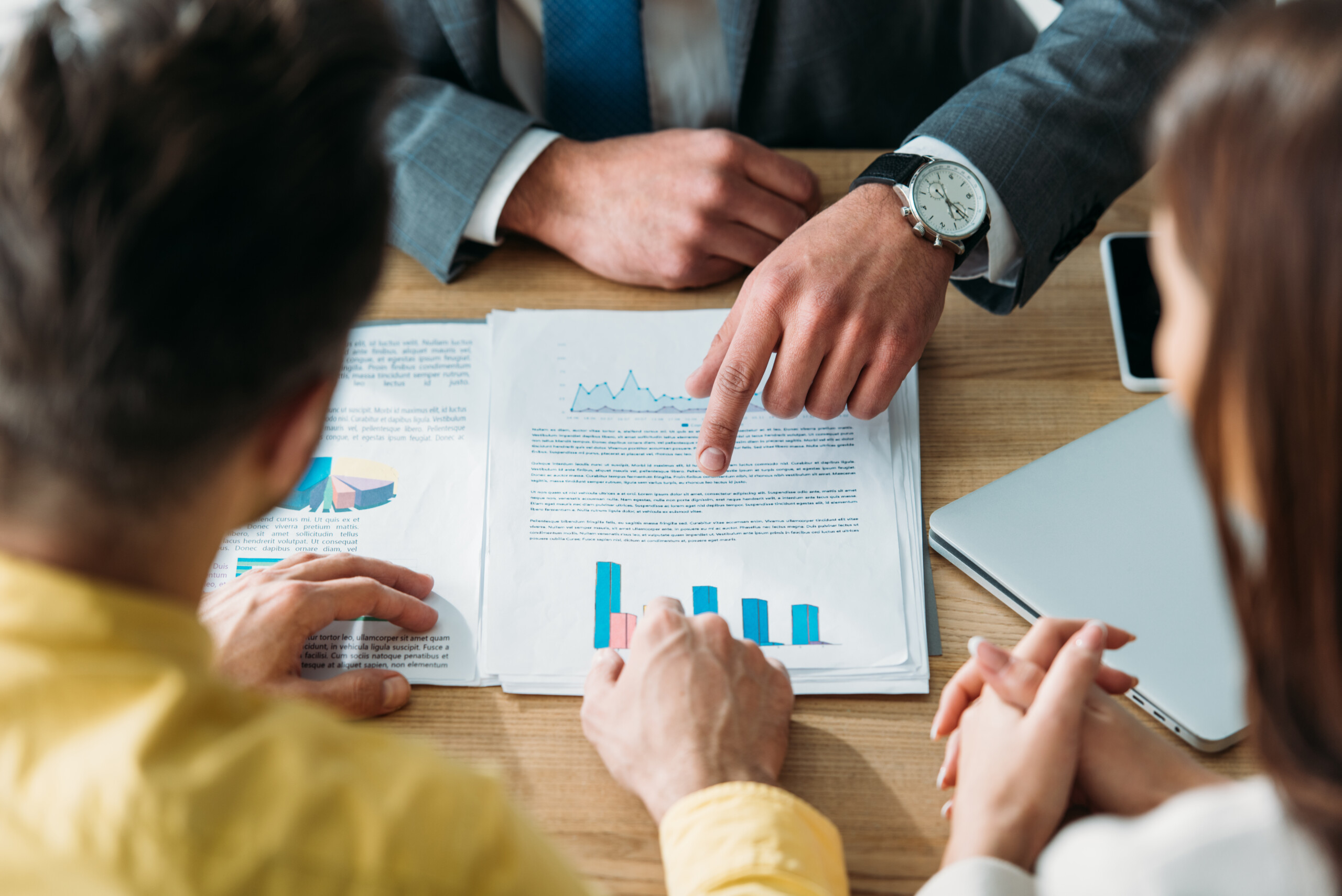 cuatro personas sentadas en una mesa analizando el crecimiento de una empresa