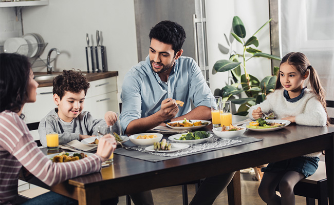 padres interactuando con sus hijos en la mesa del desayuno