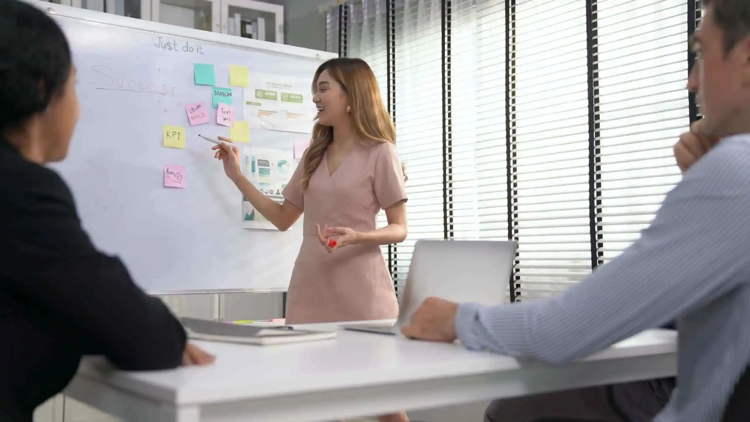 mujer parada frente al pizarron exponiendo sus ideas