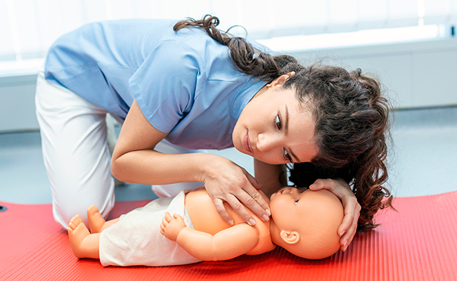 adulto comprobando si un niño en estado inconsciente respira.