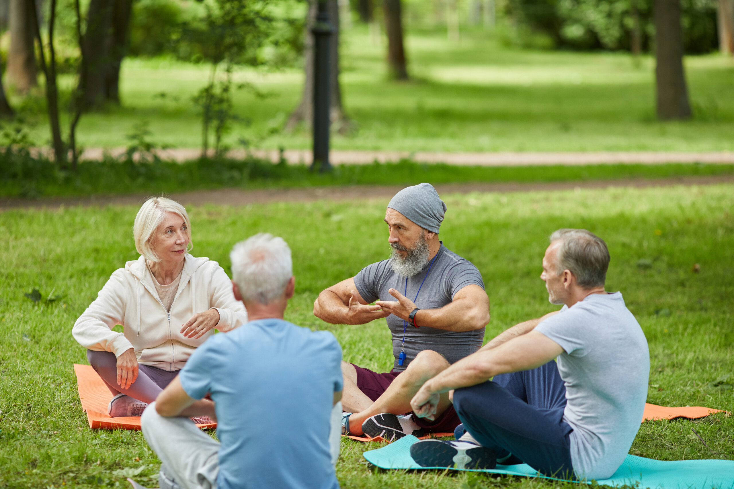 personas mayores meditando sobre el césped