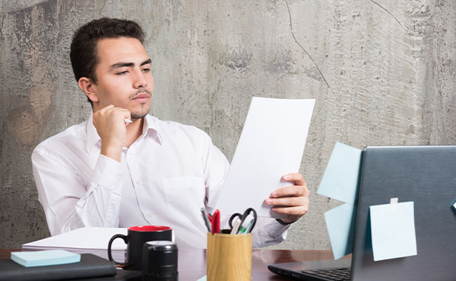 una persona evaluando propuestas, con carpetas, documentos