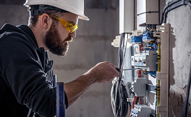 manos de un profesional utilizando un destornillador en un tablero eléctrico