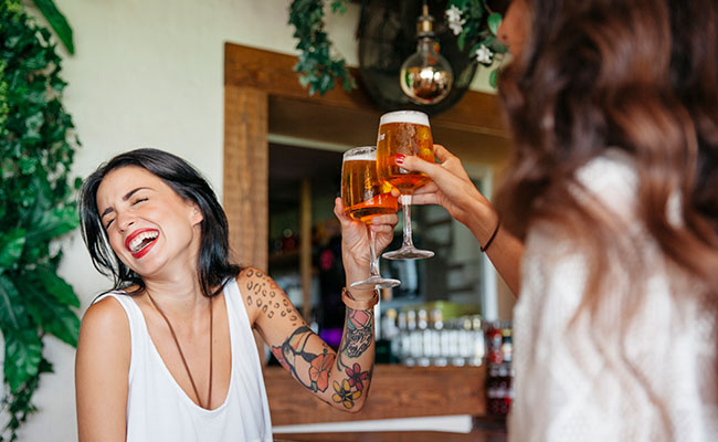 dos migas brindando con una copa