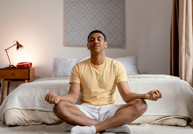 persona meditando sobre su cama antes de comenzar el día