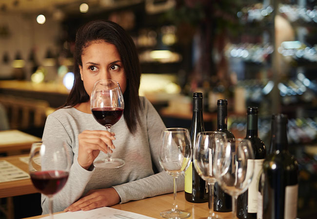 mujer degustando copa de vino tinto