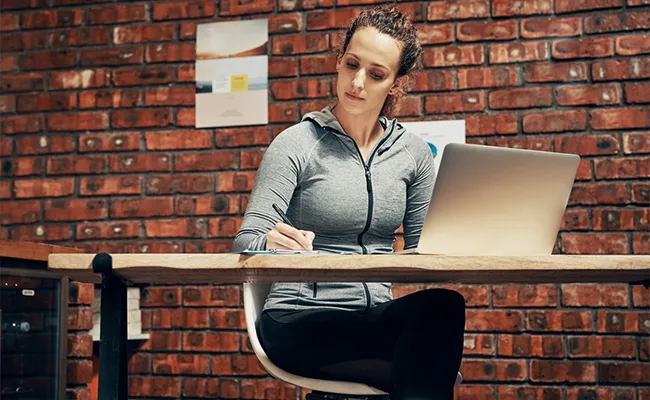 entrenadora sentada en una mesa con su notebook