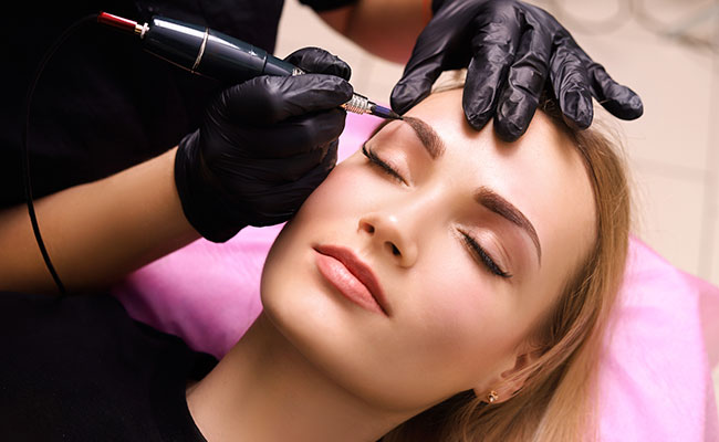mujer perfilando cejas para su clienta