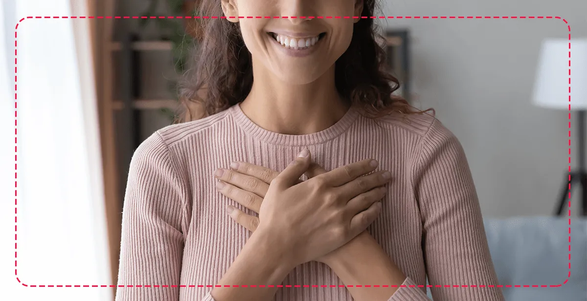 mujer sonriendo con las manos en su pecho