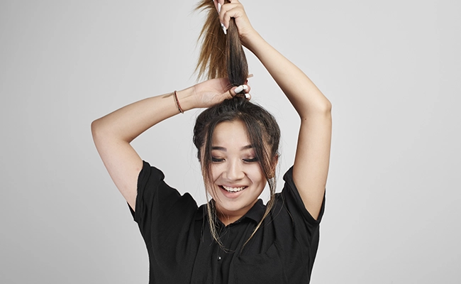 mujer dividiendo su cabello para cortarlo